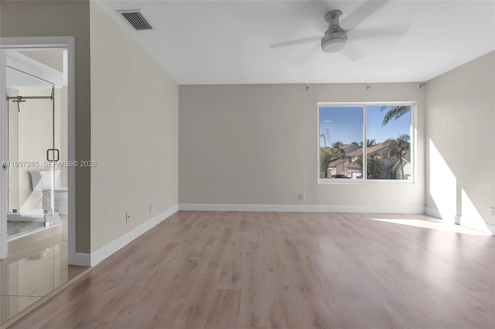 6768 Canary Palm Circle Boca Raton, FL 33433 - Photo 25 of 39 a view of an empty room with wooden floor and a window