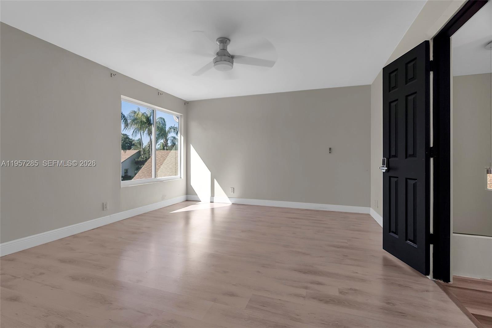 6768 Canary Palm Circle Boca Raton, FL 33433 - Photo 26 of 39 a view of an empty room with wooden floor and a window