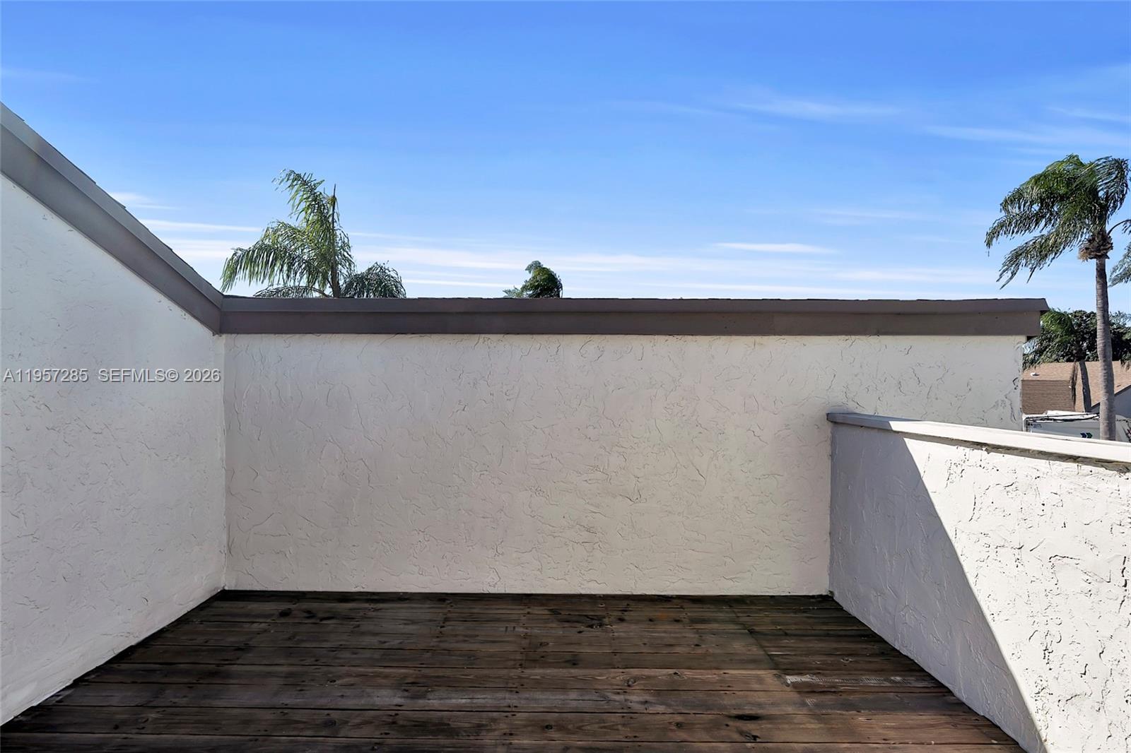 6768 Canary Palm Circle Boca Raton, FL 33433 - Photo 31 of 39 a view of balcony with wooden floor and palm trees