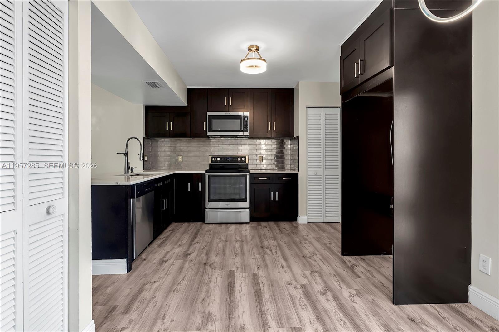 6768 Canary Palm Circle Boca Raton, FL 33433 - Photo 5 of 39 a kitchen with stainless steel appliances granite countertop a refrigerator a sink a stove and wooden cabinets