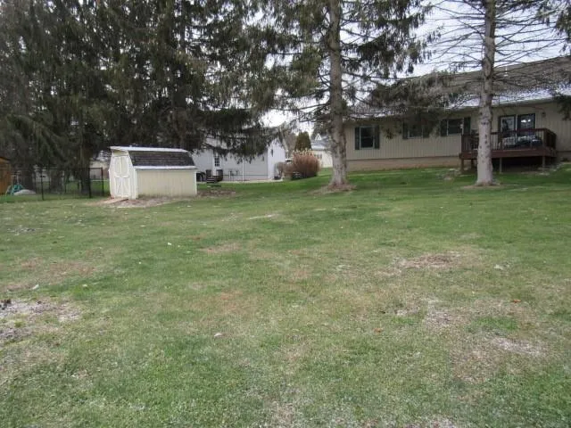 a front view of a house with a garden and trees
