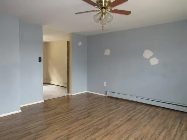 a view of an empty room with wooden floor