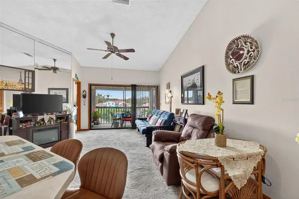 a living room with furniture kitchen view and a large window