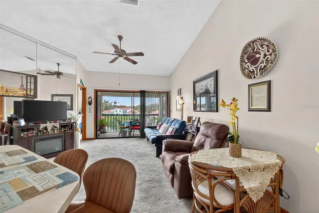 a living room with furniture kitchen view and a large window