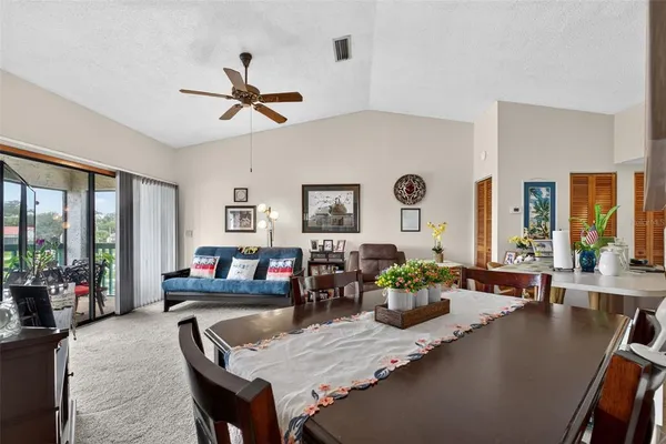 a living room with furniture kitchen view and a window