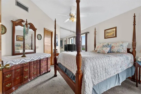 a bedroom with a bed window and a flat screen tv