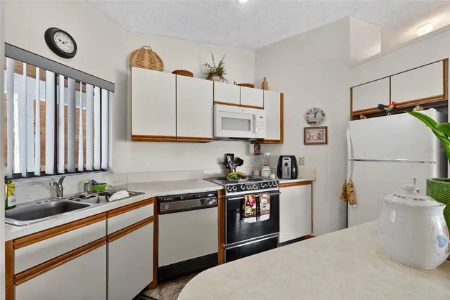 a kitchen with stainless steel appliances granite countertop a sink a stove and refrigerator