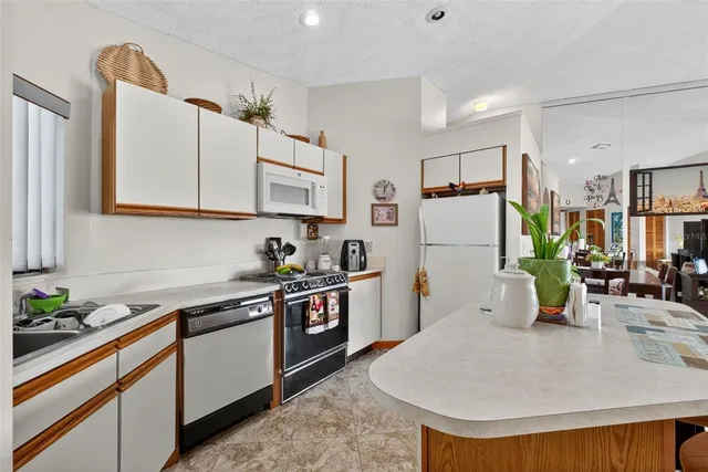 a kitchen with stainless steel appliances kitchen island granite countertop a sink and cabinets