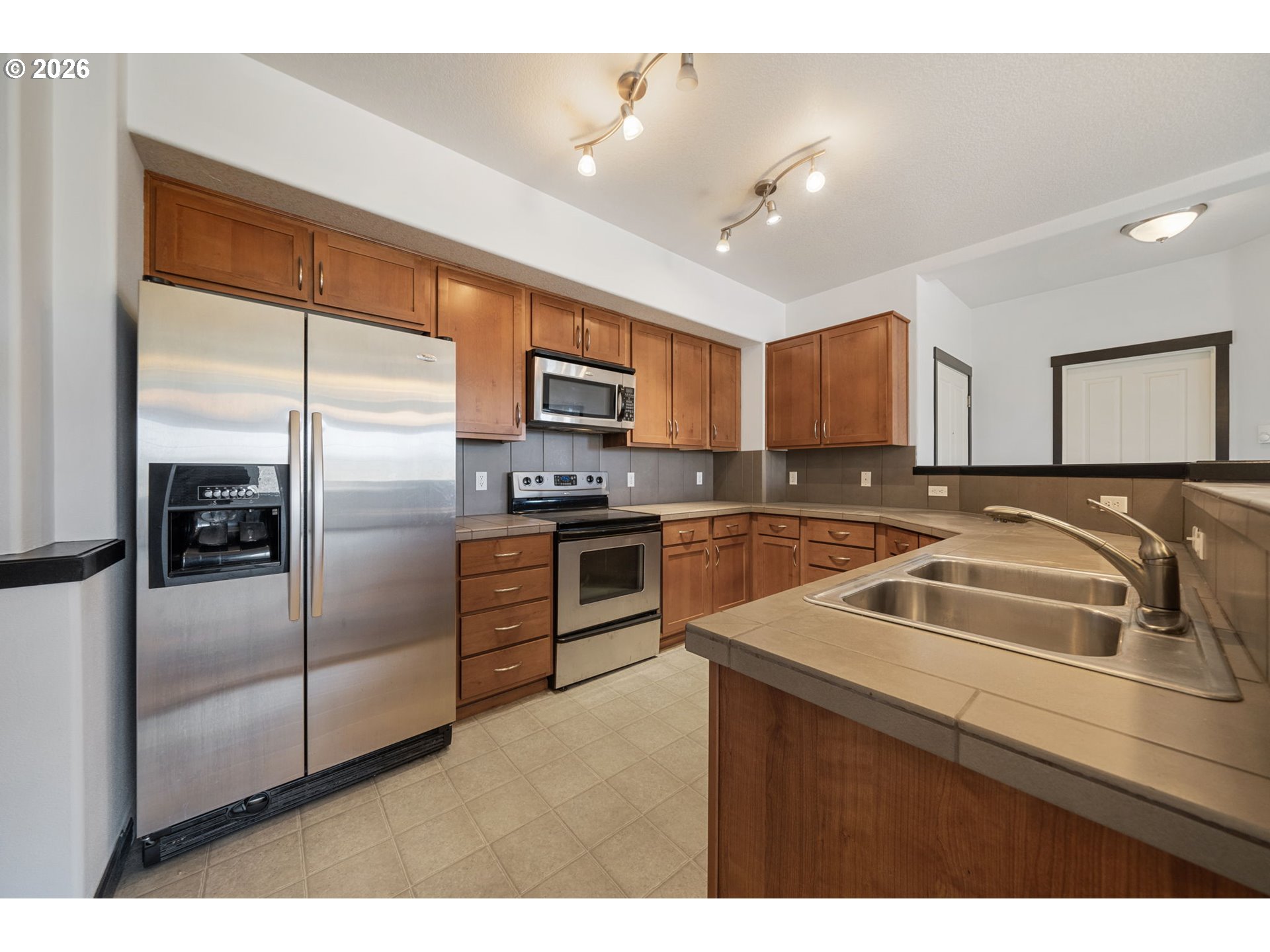 695 Northwest Falling Waters Lane, Unit 304 Portland, OR 97229 - Photo 11 of 25 a kitchen with a refrigerator sink and microwave