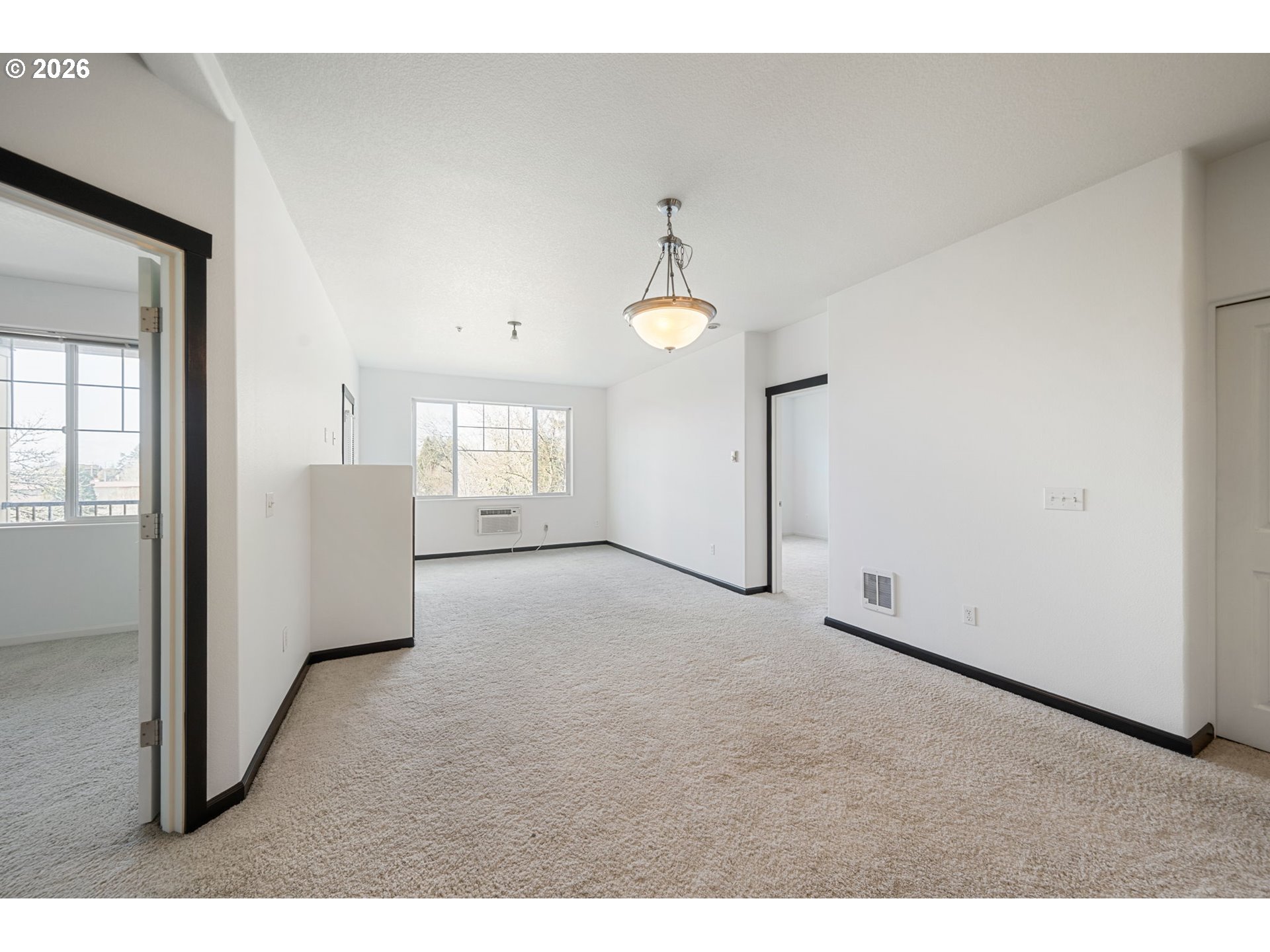 695 Northwest Falling Waters Lane, Unit 304 Portland, OR 97229 - Photo 7 of 25 a view of a big room with windows and chandelier fan