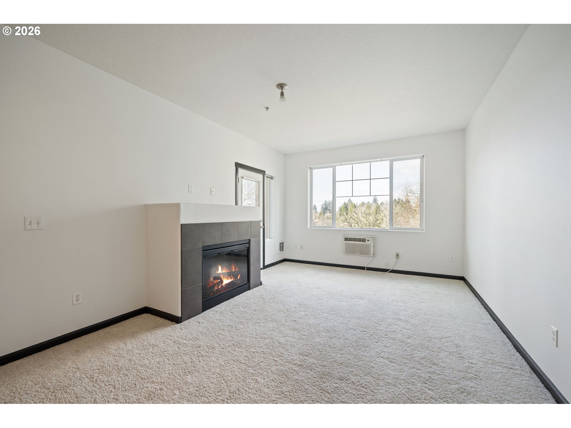 695 Northwest Falling Waters Lane, Unit 304 Portland, OR 97229 - Photo 8 of 25 a view of an empty room with a fireplace and a window