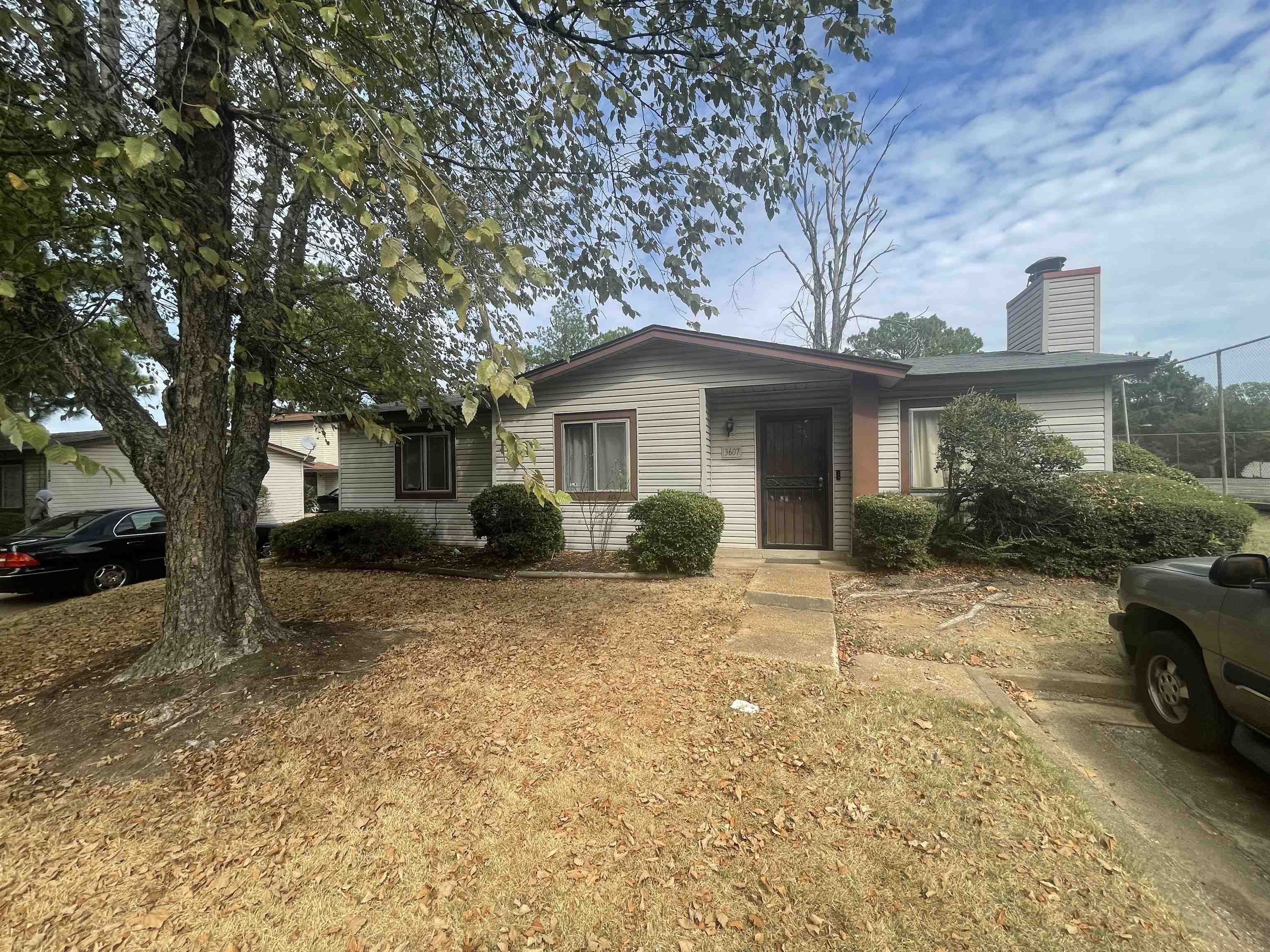 a view of a house with a yard and large tree