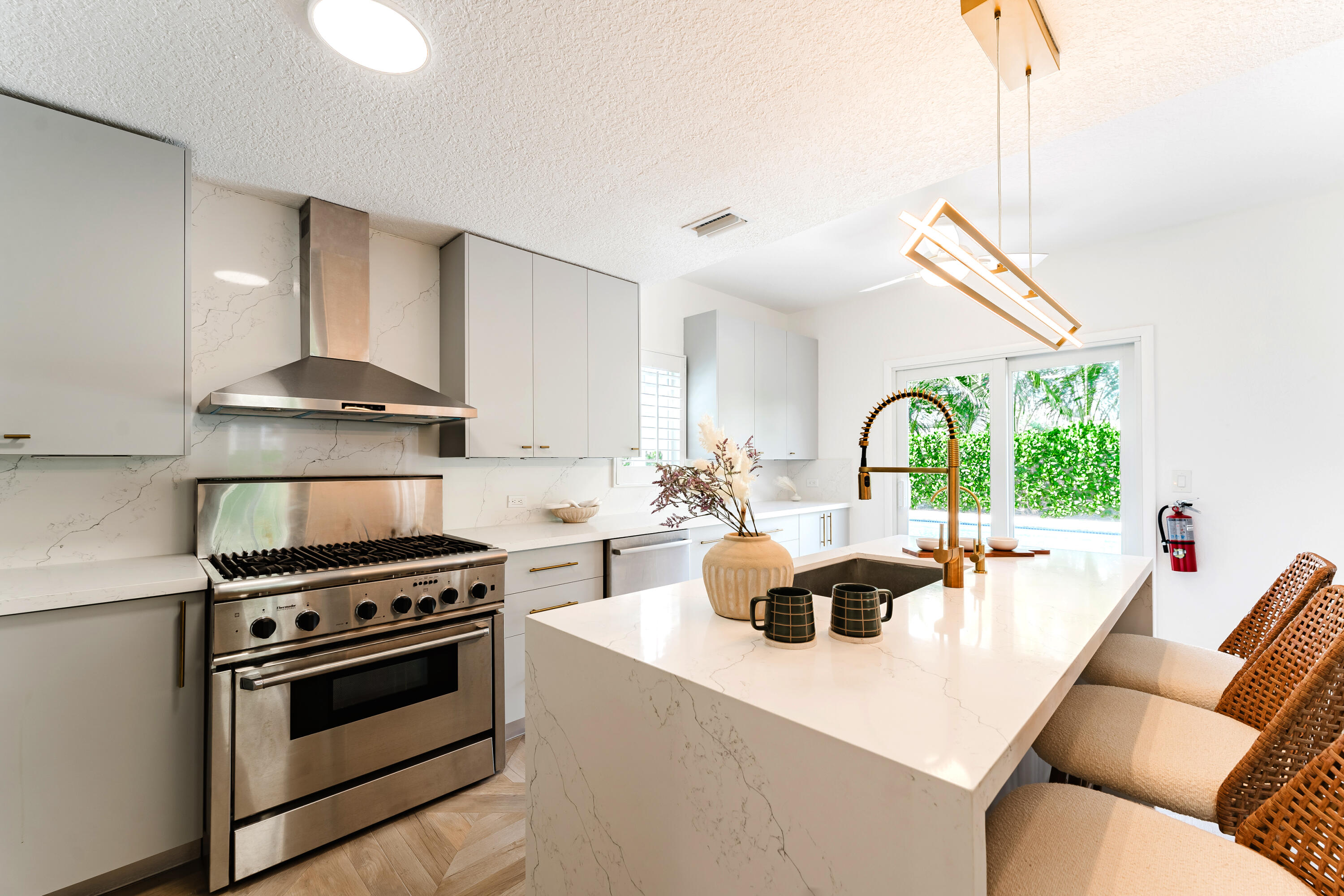 921 Ortega Road West Palm Beach, FL 33405 - Photo 11 of 60 a kitchen with a stove a sink dishwasher a stove and a dining table with wooden floor