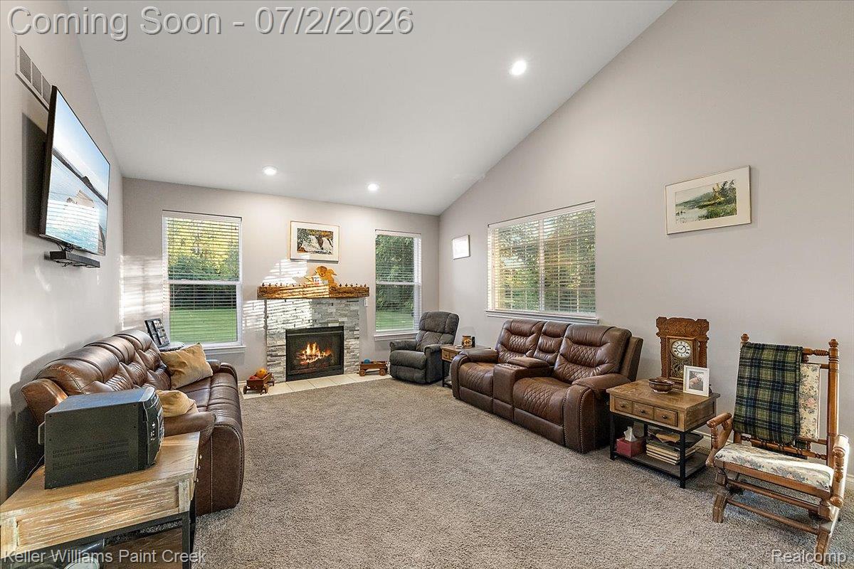 54230 Card Road Macomb, MI 48042 - Photo 43 of 73 Living area featuring vaulted ceilings, recessed lighting, and a stone-clad fireplace with a decorative wood mantel