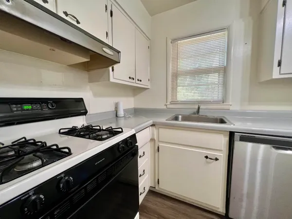 a kitchen with stainless steel appliances a sink dishwasher stove and cabinets