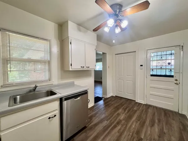 a kitchen that has a sink cabinets and window
