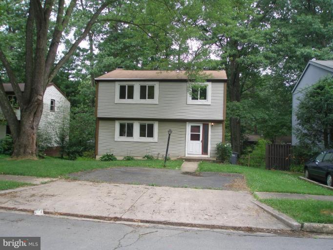 2306 Whitetail Court Reston, VA 20191 - Photo 1 of 8 a front view of a house with a garden and trees