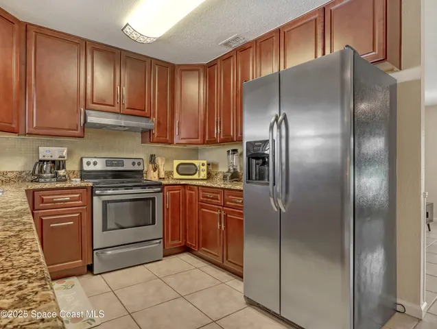 a kitchen with stainless steel appliances granite countertop a refrigerator sink and cabinets