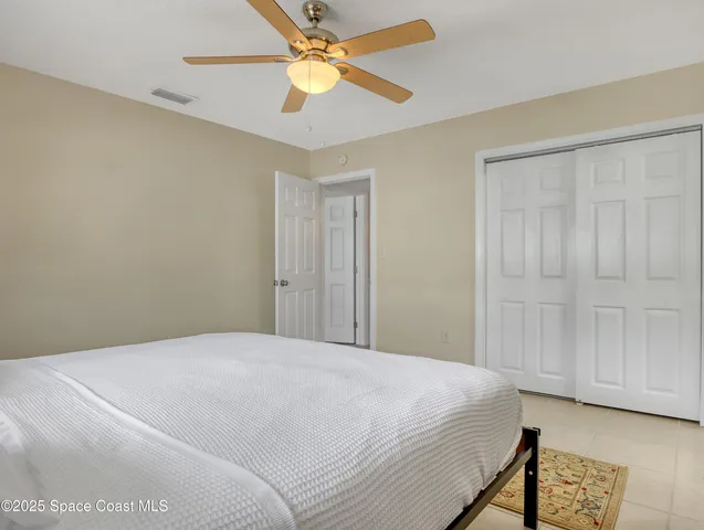 a bedroom with a bed and a ceiling fan