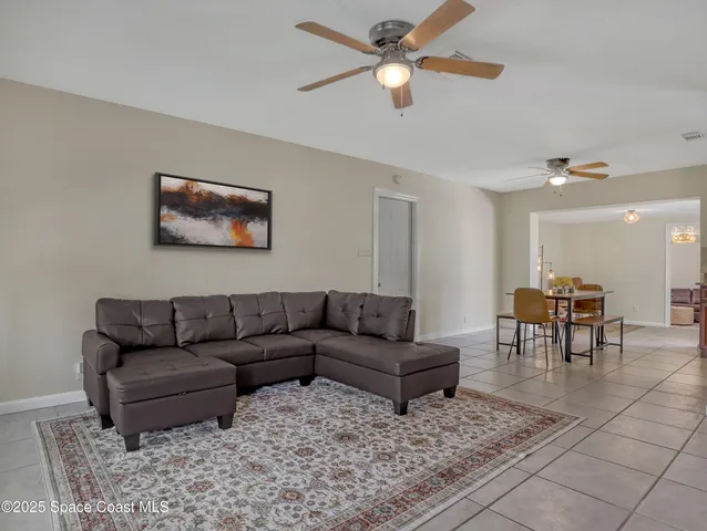 a living room with furniture and a view of kitchen