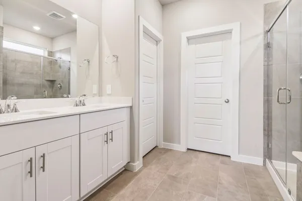 a bathroom with a shower sink and mirror