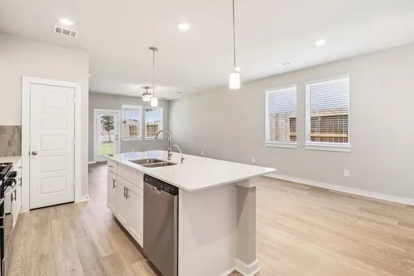 a kitchen with a stove and a wooden floor