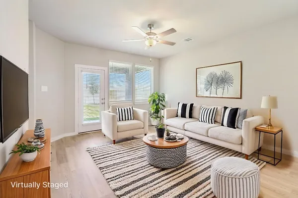 a living room with furniture a rug and a flat screen tv