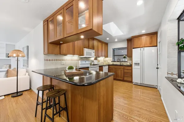a kitchen with stainless steel appliances granite countertop a sink a stove and a refrigerator