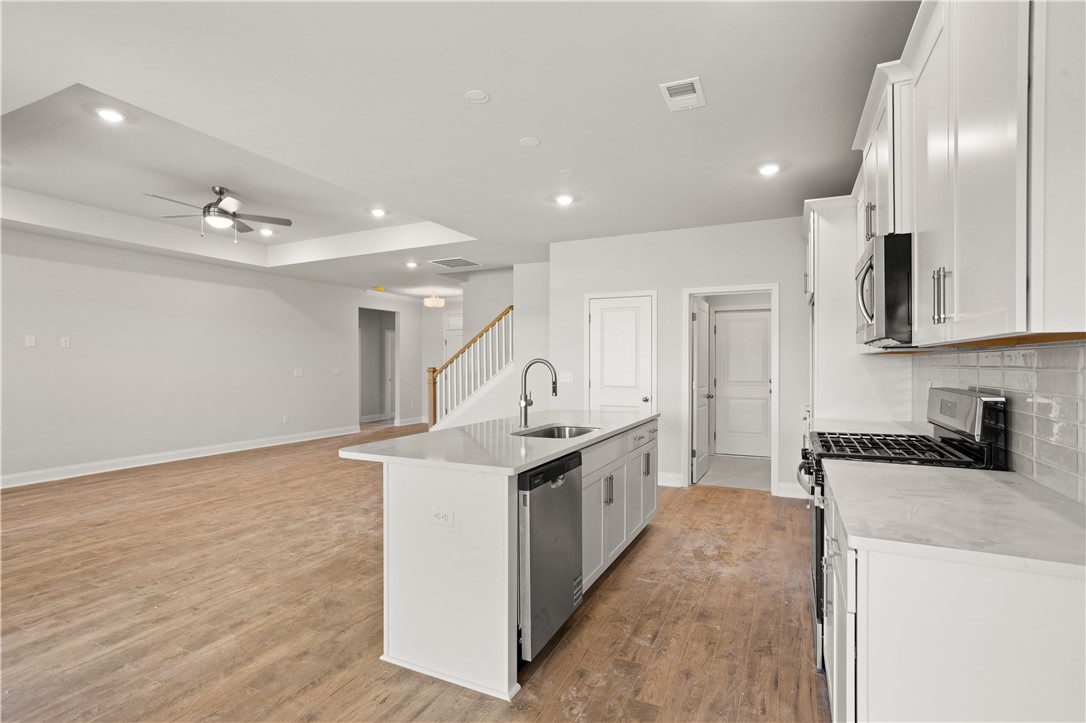 554 Hydrangea Street, Unit LOT 67 Seneca, SC 29678 - Photo 8 of 26 An open-concept living space integrates a stylish kitchen with an inviting island and hardwood-style flooring.