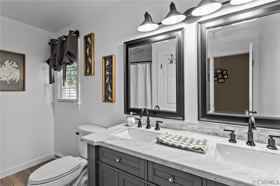 3905 Cresthill Road Chester, VA 23831 - Photo 29 of 49 a bathroom with a granite countertop sink mirror vanity and toilet