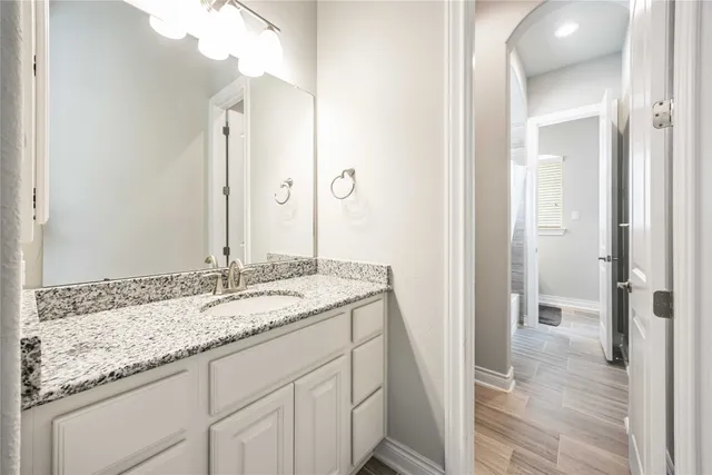 a bathroom with a granite countertop sink and a mirror