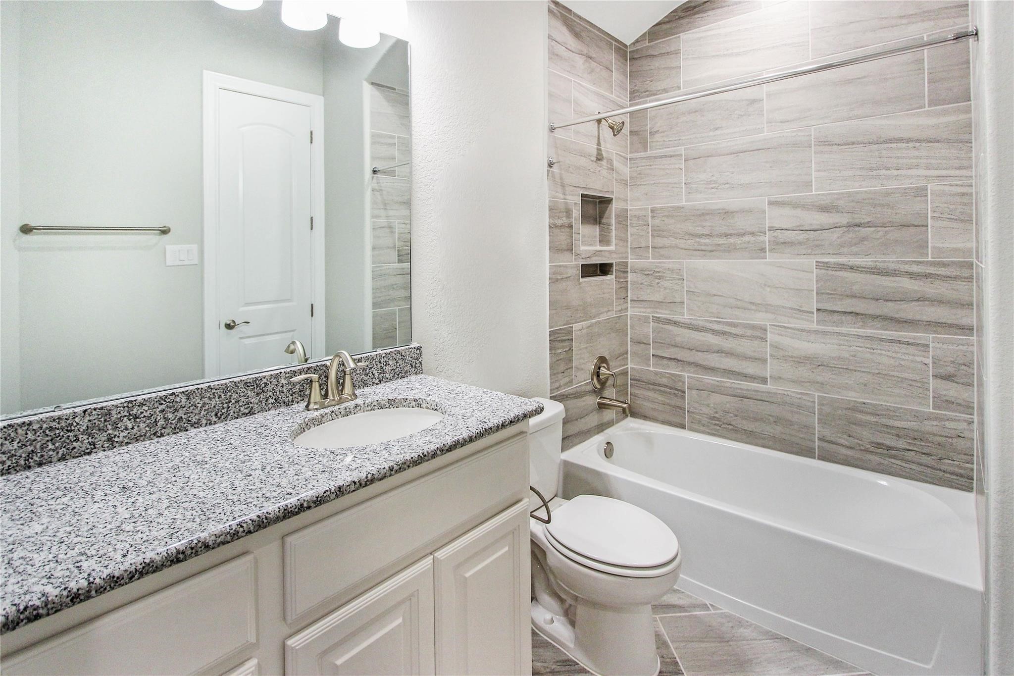 5202 Creekmore Circle Spring, TX 77389 - Photo 17 of 24 a bathroom with a granite countertop toilet sink and bathtub