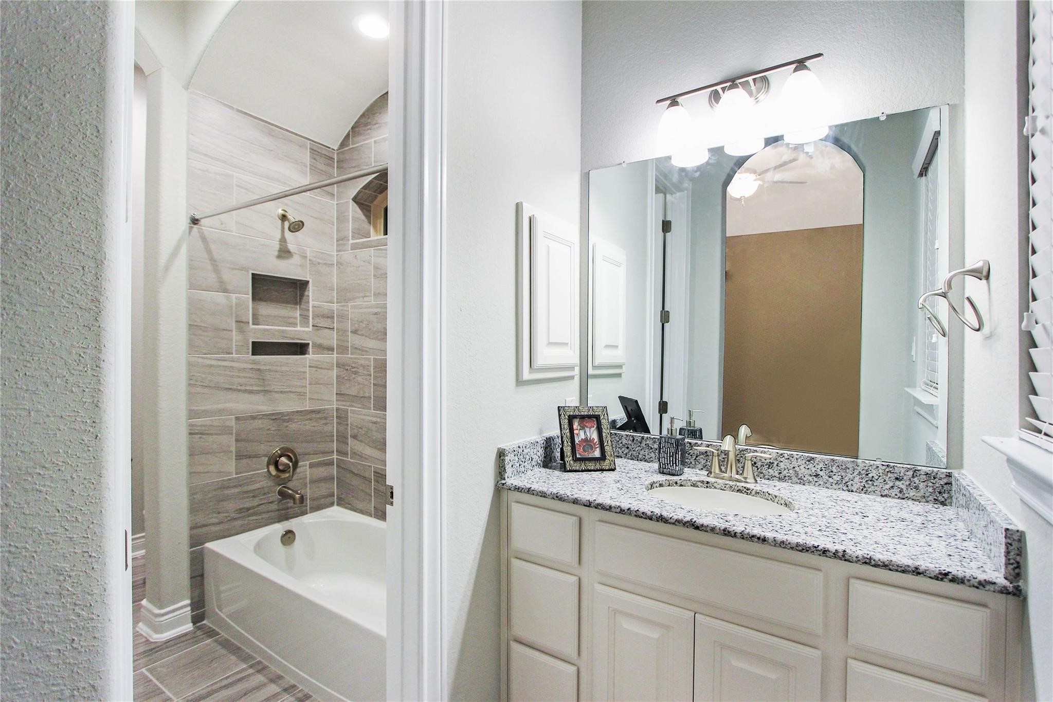 5202 Creekmore Circle Spring, TX 77389 - Photo 18 of 24 a bathroom with a tub sink double vanity and mirror