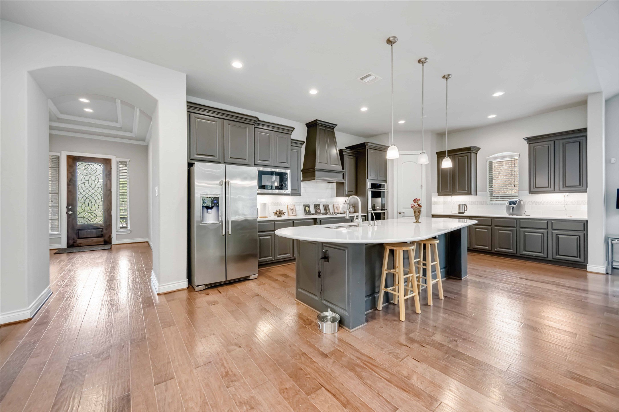 5202 Creekmore Circle Spring, TX 77389 - Photo 5 of 24 a kitchen with stainless steel appliances kitchen island granite countertop a refrigerator a oven a sink a dining table and chairs with wooden floor
