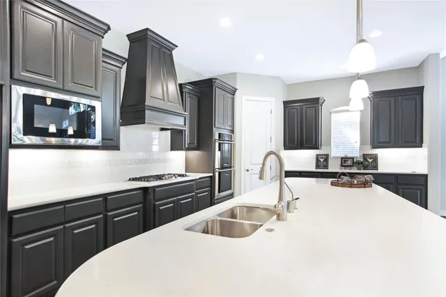 a kitchen with stainless steel appliances granite countertop a sink stove and cabinets