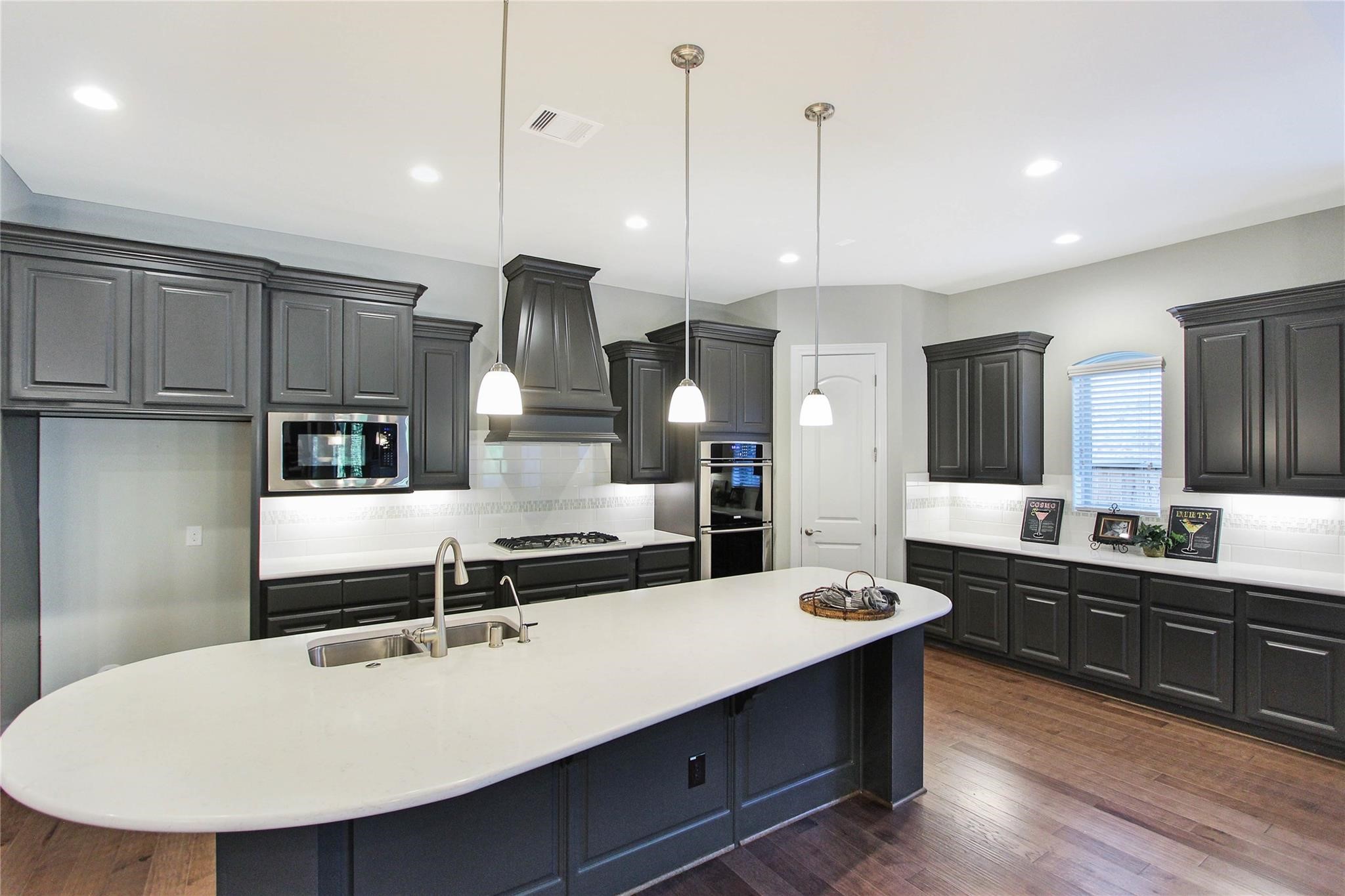 5202 Creekmore Circle Spring, TX 77389 - Photo 8 of 24 a kitchen with kitchen island a sink stainless steel appliances and cabinets