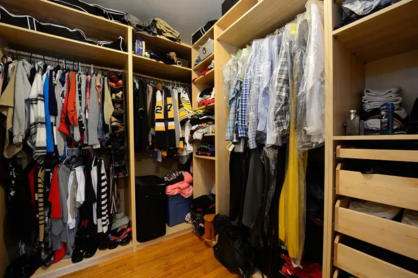 a view of walk in closet with clothes and shoes