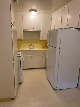 a view of a kitchen with a sink and refrigerator