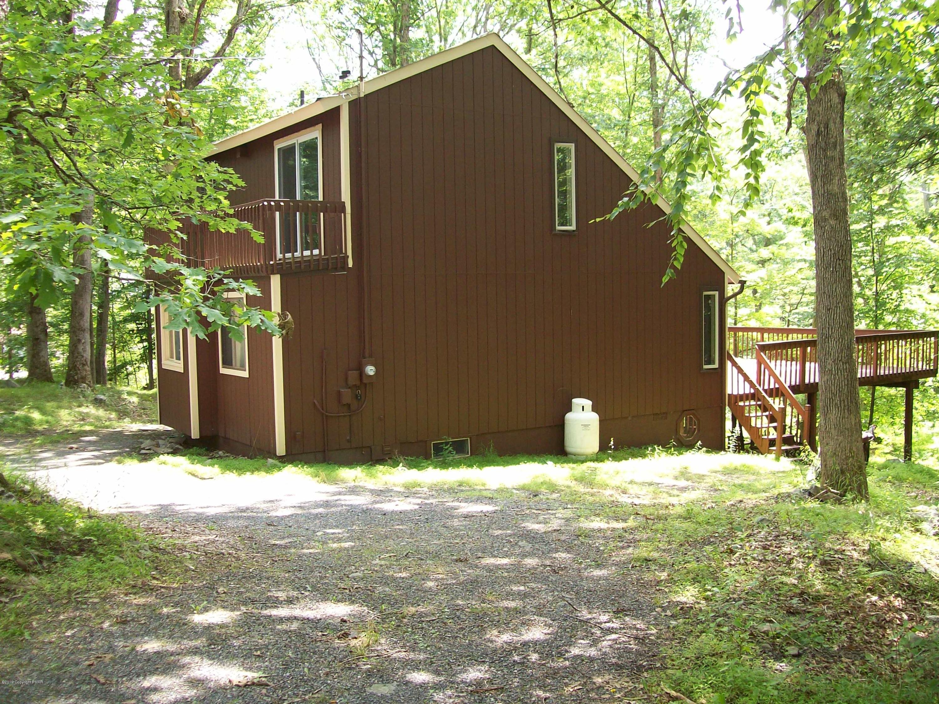 243 Canterbury Road Bushkill, PA 18324 - Photo 2 of 29 a backyard of a house with large trees and a yard