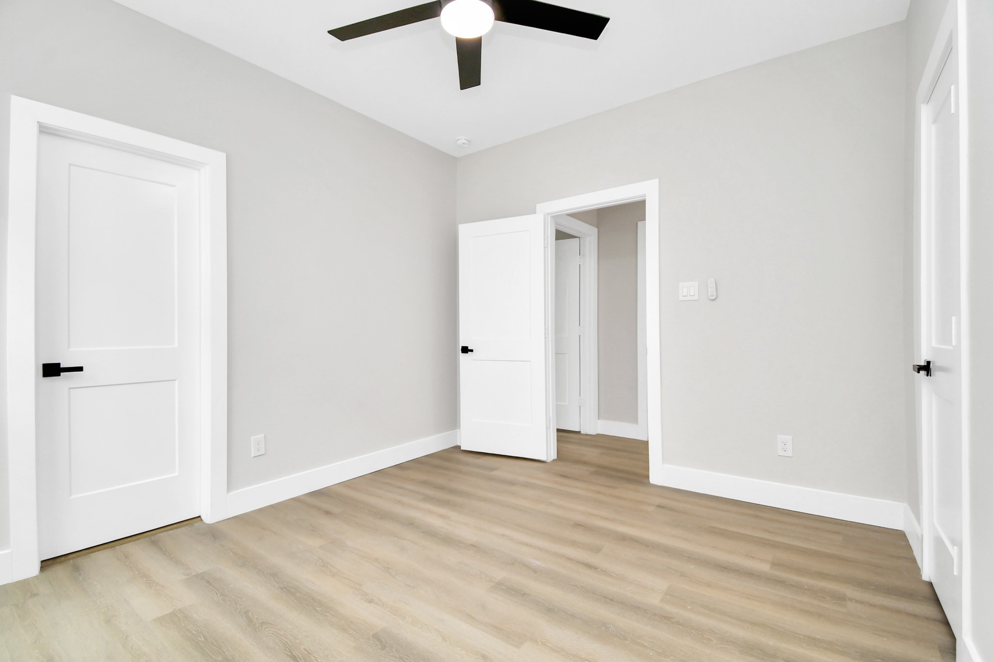 8409 Sunnyhill Street Houston, TX 77088 - Photo 12 of 13 an empty room with ceiling fan and wooden floor