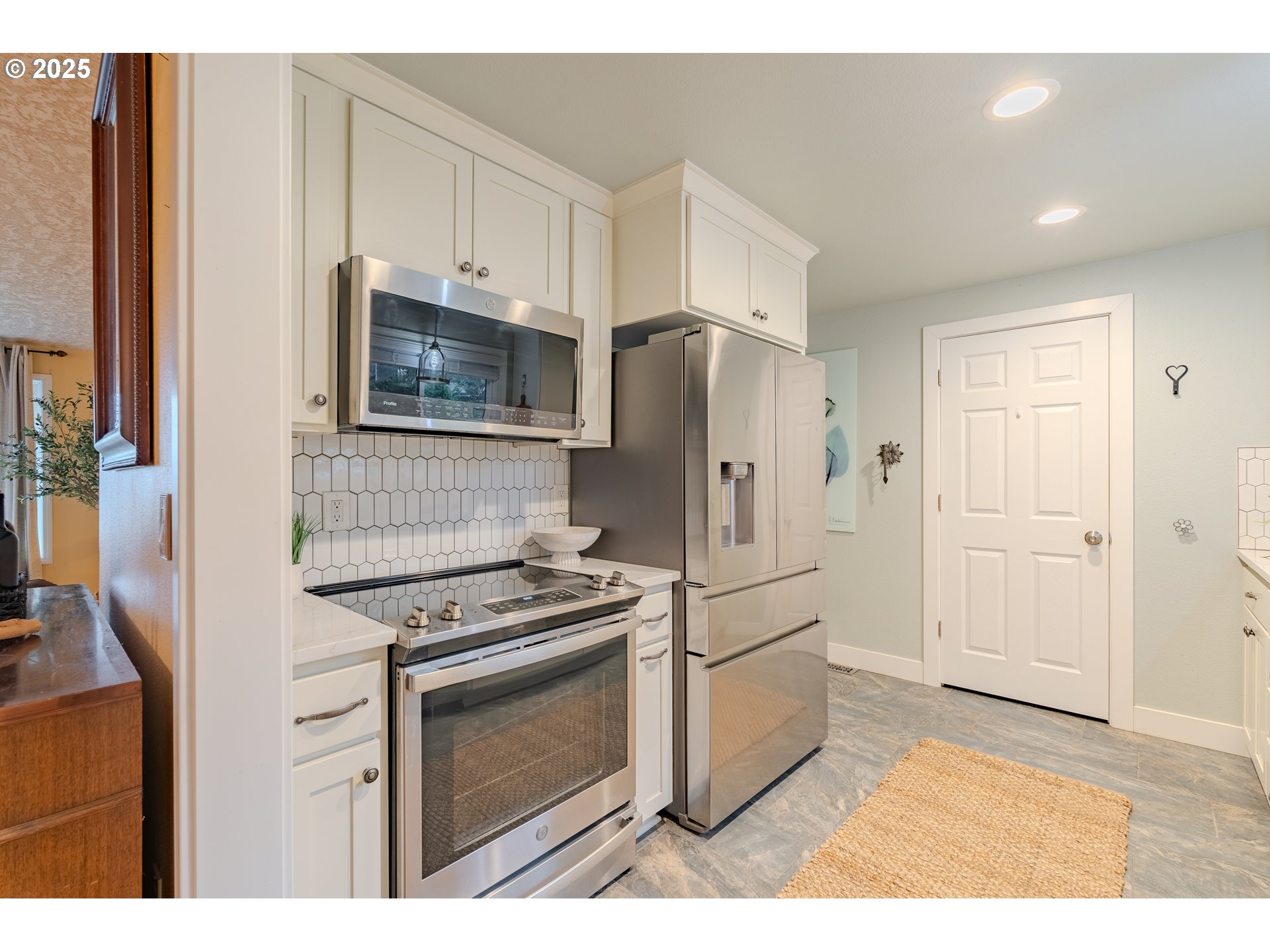 3270 Northwest Ivy Lane Camas, WA 98607 - Photo 10 of 26 a kitchen with white cabinets and stainless steel appliances