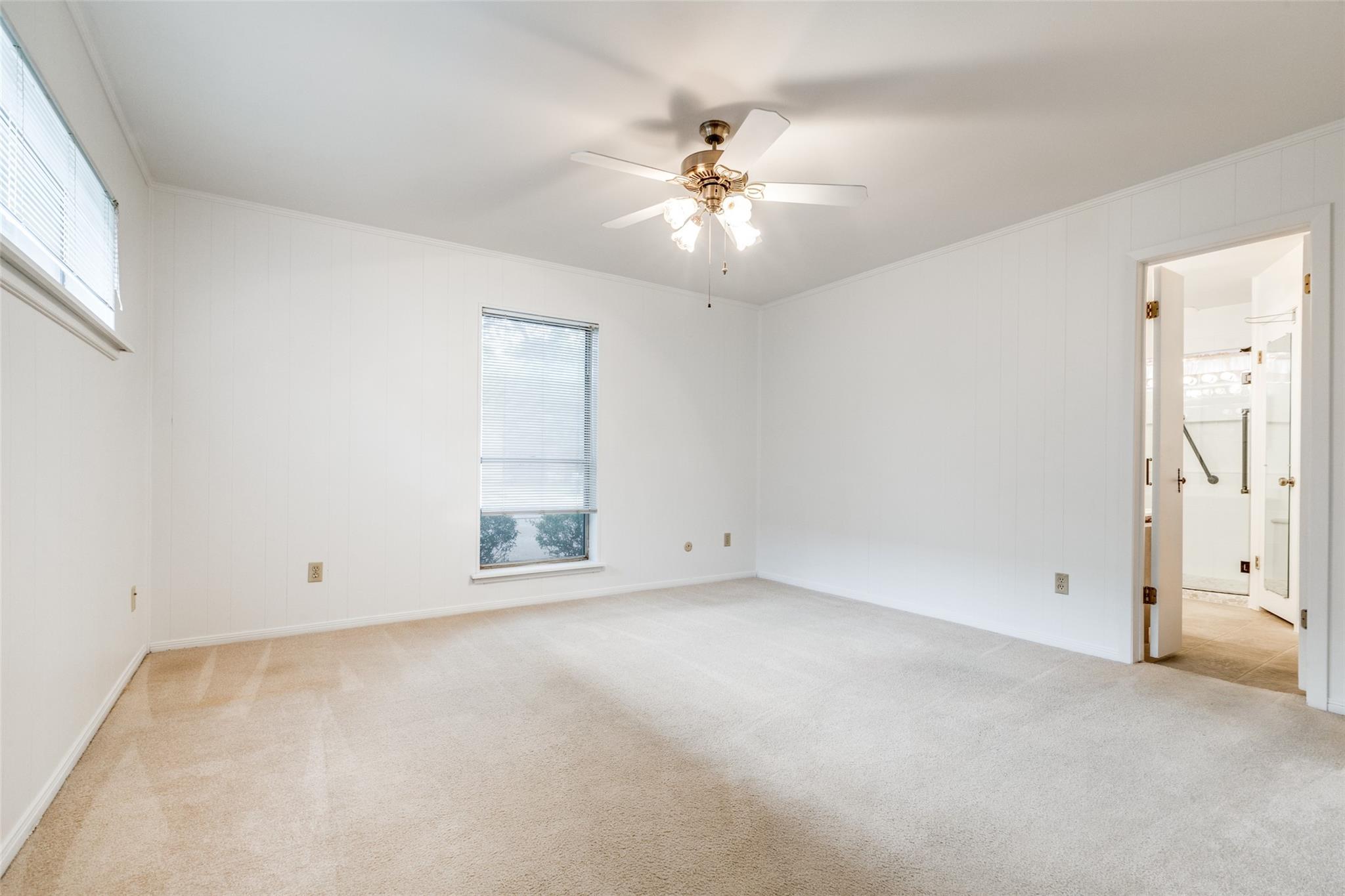 20303 Hampshire Rocks Drive Katy, TX 77450 - Photo 7 of 11 an empty room with chandelier fan and windows
