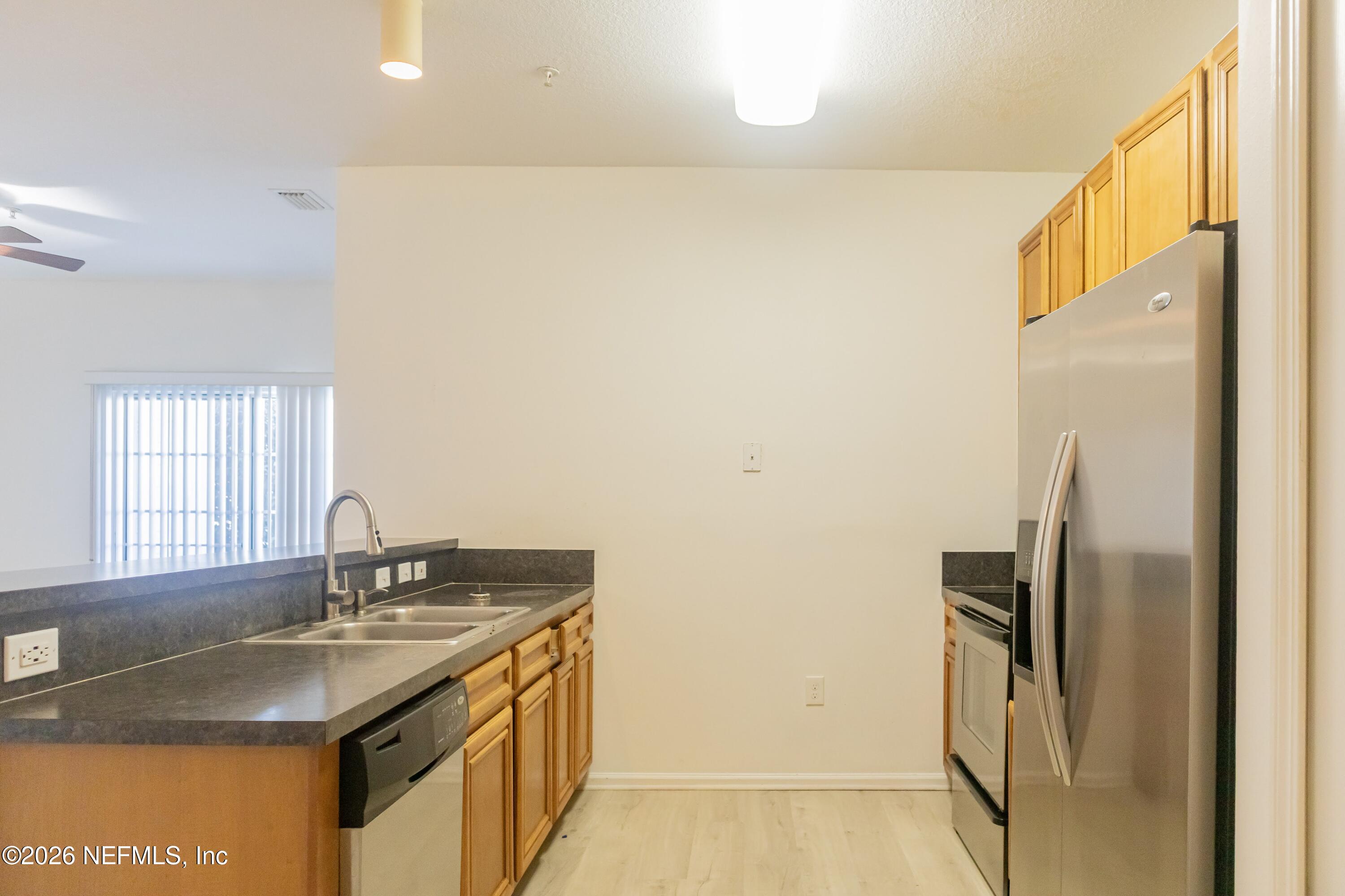 a kitchen with stainless steel appliances granite countertop a sink and a refrigerator