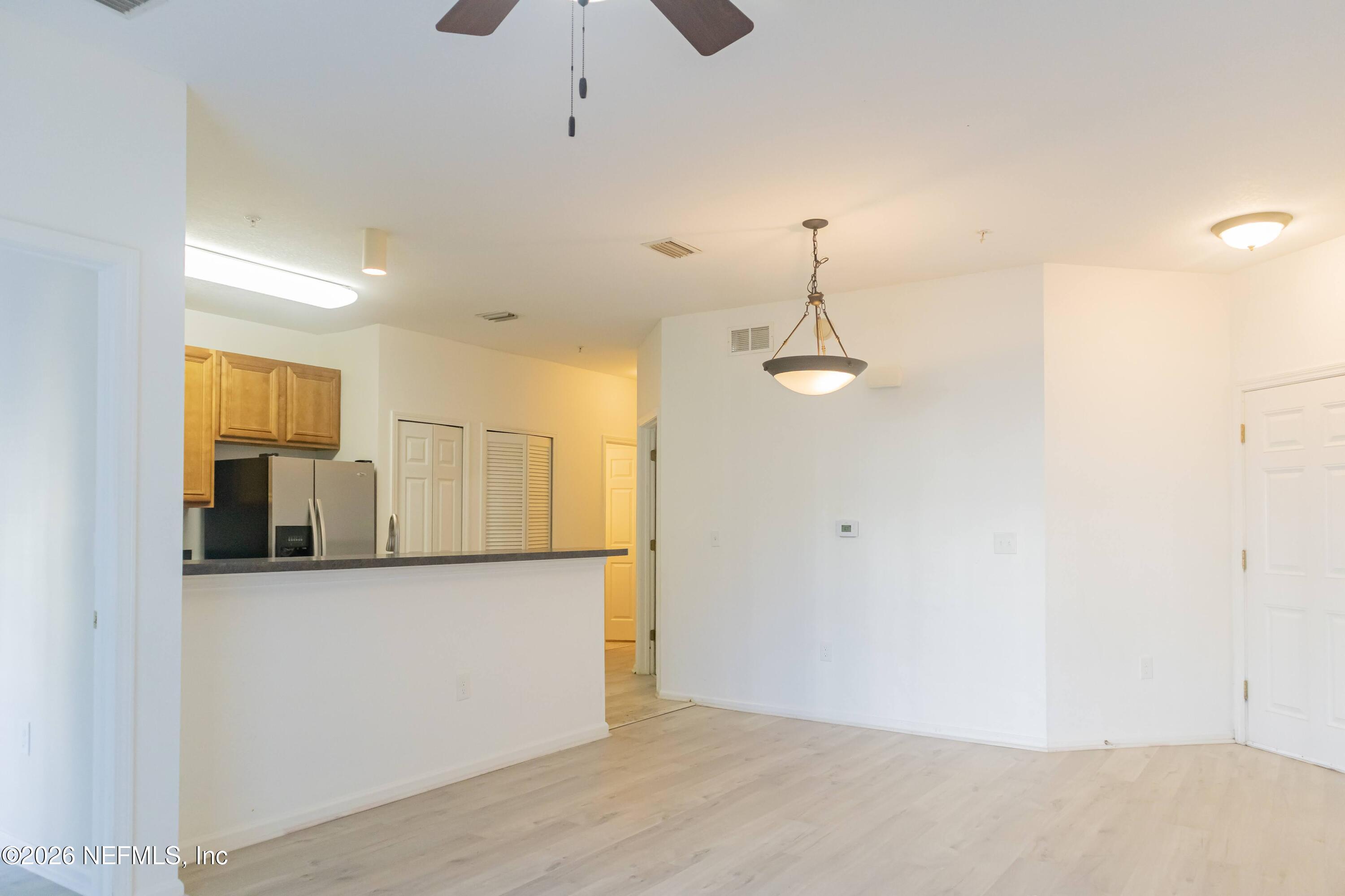 8226 Green Parrot Road, Unit 105 Jacksonville, FL 32256 - Photo 2 of 17 a view of a kitchen with a sink and dishwasher a refrigerator with wooden floor