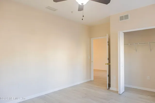 an empty room with a ceiling fan and carpet