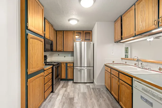 a kitchen with stainless steel appliances granite countertop a refrigerator stove and sink