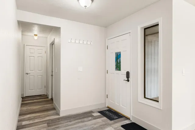 a view of a hallway with wooden floor and closet