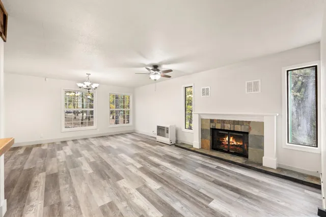a view of an empty room with a fireplace and a window