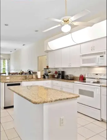 a kitchen with stainless steel appliances granite countertop a sink a stove and cabinets