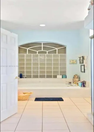 a bathroom with a tub sink and next to a window